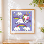 Finished unicorn with magic wand and rainbow cross stitch artwork displayed