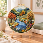 Valley river autumn scenery embroidery kit finished hoop displayed on a wooden stand as cozy tabletop decor