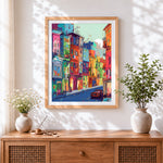 Finished vibrant colourful city street cross stitch artwork displayed