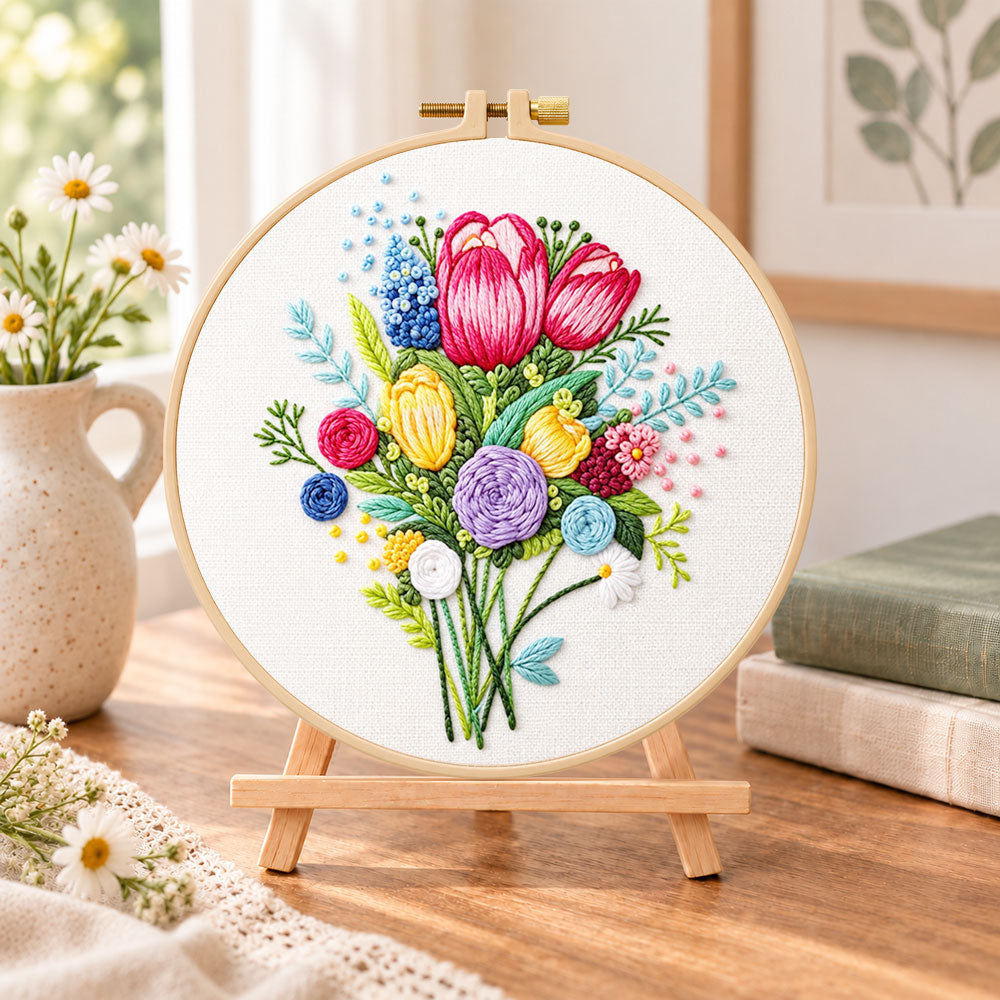 Vibrant flower bouquet embroidery kit finished hoop displayed on a wooden stand as cosy tabletop decor