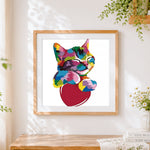 Finished vibrant pop art cat on a red heart cross stitch artwork displayed