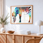 Vibrant rainbow watercolour zebra cross stitch artwork displayed on wall as home decor