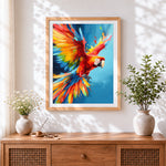 Finished vibrant scarlet macaw in flight cross stitch artwork displayed