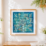 Finished vibrant turquoise mandala cross stitch artwork displayed