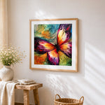 Vibrant watercolour splatter butterfly cross stitch artwork displayed on wall as home decor