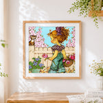 Finished vintage girl picking flowers cross stitch artwork displayed