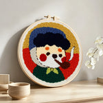 Vintage style cartoon character with pipe punch needle artwork displayed on a table