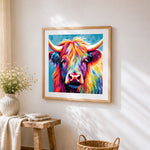 Warm toned highland cow cross stitch artwork displayed on wall as home decor