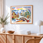 Watercolour christmas village with bridge cross stitch artwork displayed on wall as home decor