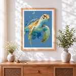 Finished watercolour sea turtle splatter cross stitch artwork displayed