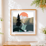 Finished waterfall and pine trees landscape cross stitch artwork displayed