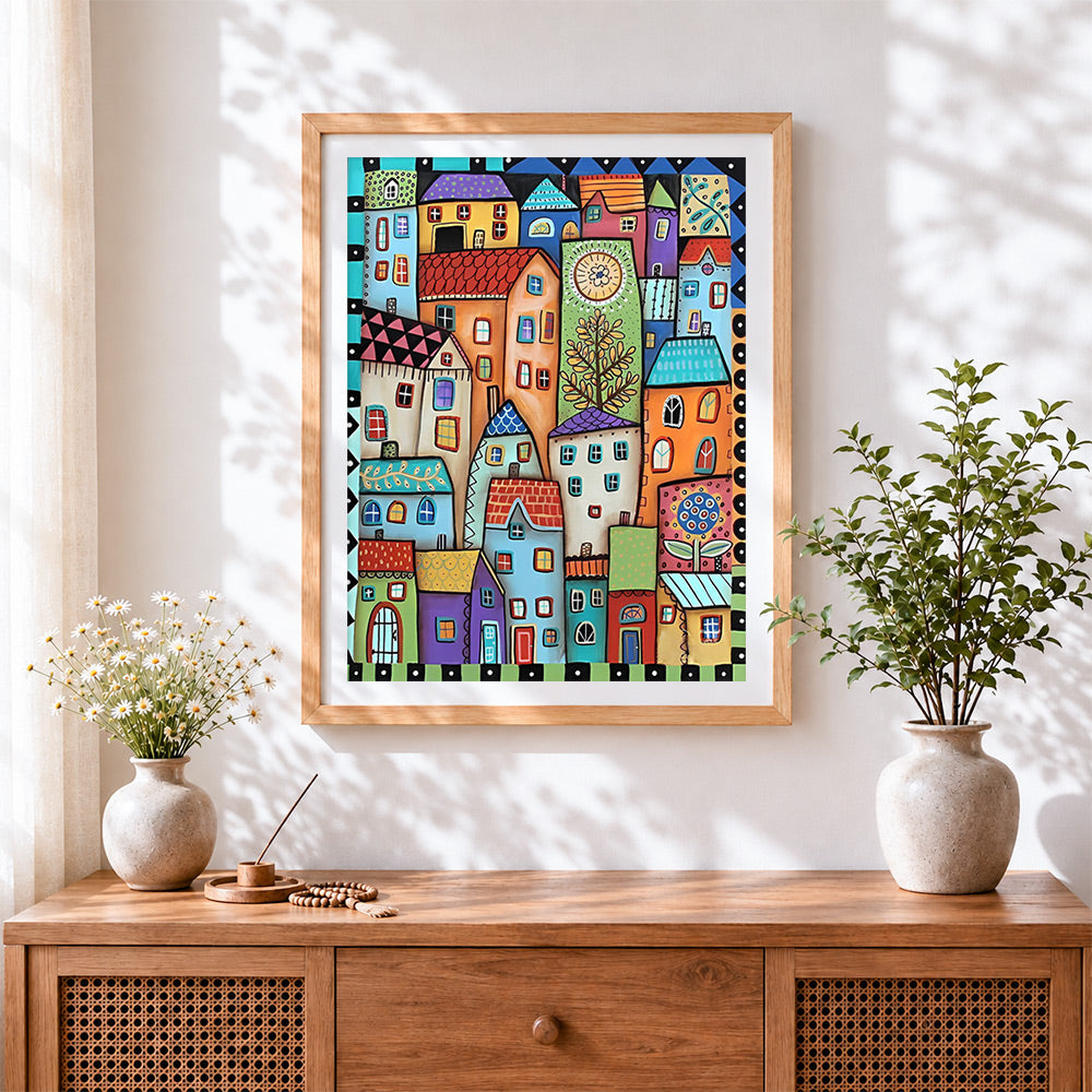 Finished whimsical colourful village cross stitch artwork displayed