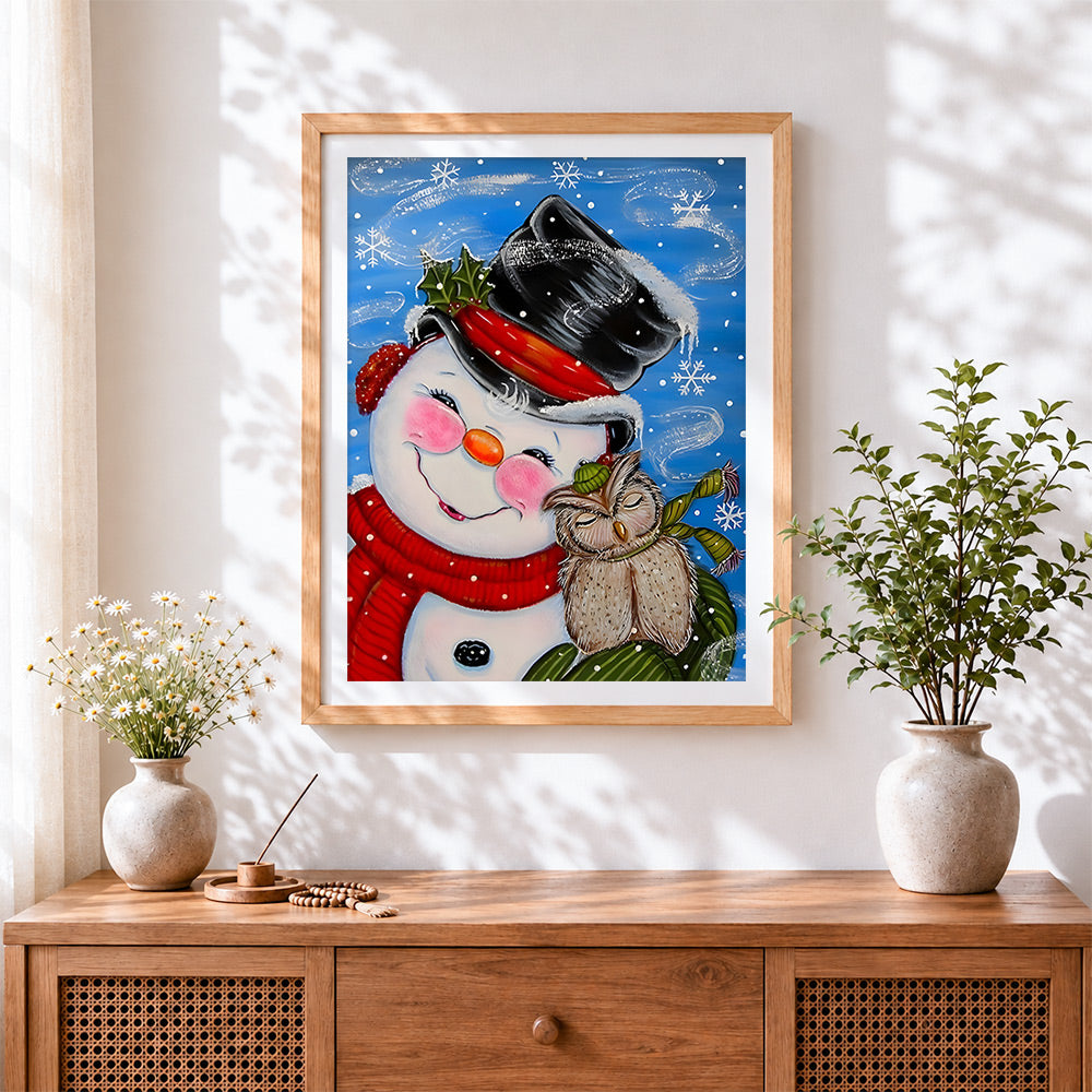 Finished whimsical snowman and owl in the snow cross stitch artwork displayed