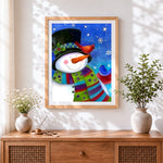 Finished whimsical snowman and winter birds cross stitch artwork displayed