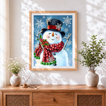 Finished whimsical snowman with snowflakes cross stitch artwork displayed