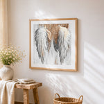 White angel wings cross stitch artwork displayed on wall as home decor