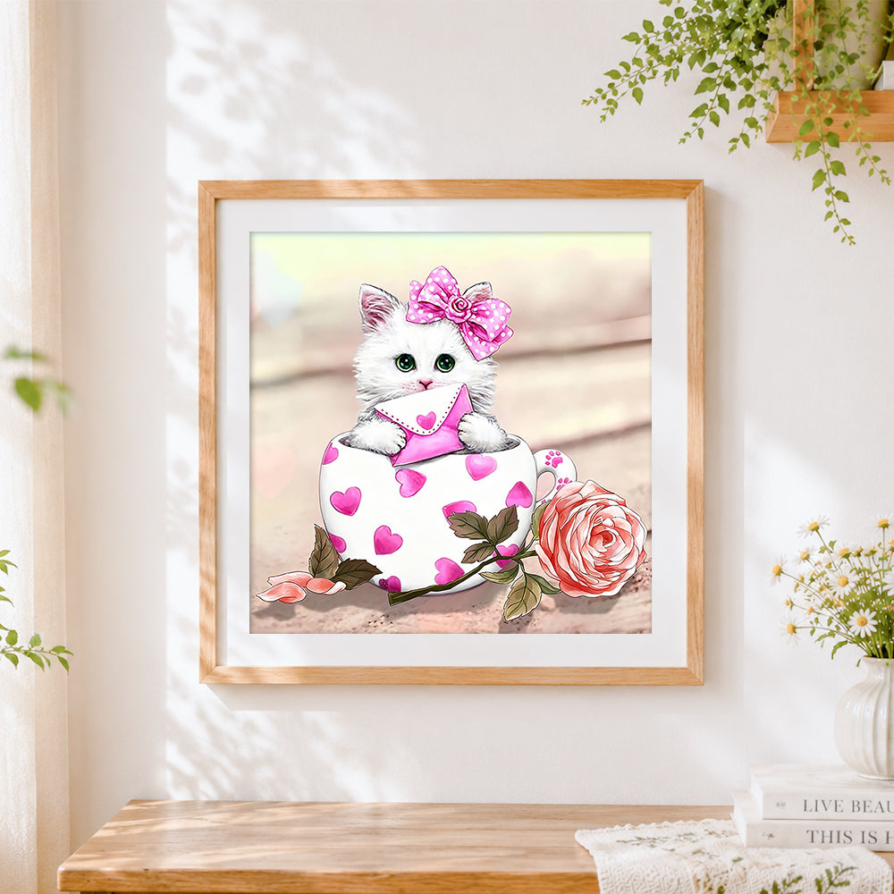 Finished white cat with heart envelope in teacup cross stitch artwork displayed