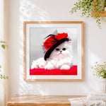 Finished white cat with red hat cross stitch artwork displayed
