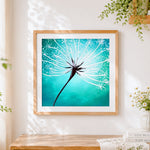 Finished white dandelion on green background cross stitch artwork displayed