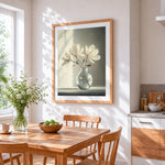 White magnolia branches in a glass vase cross stitch artwork displayed on wall as home decor