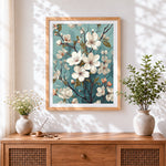 Finished white magnolia on teal background cross stitch artwork displayed