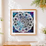 Finished white mandala on galaxy background cross stitch artwork displayed