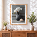 Finished white orchids in a dark vase with shell cross stitch artwork displayed