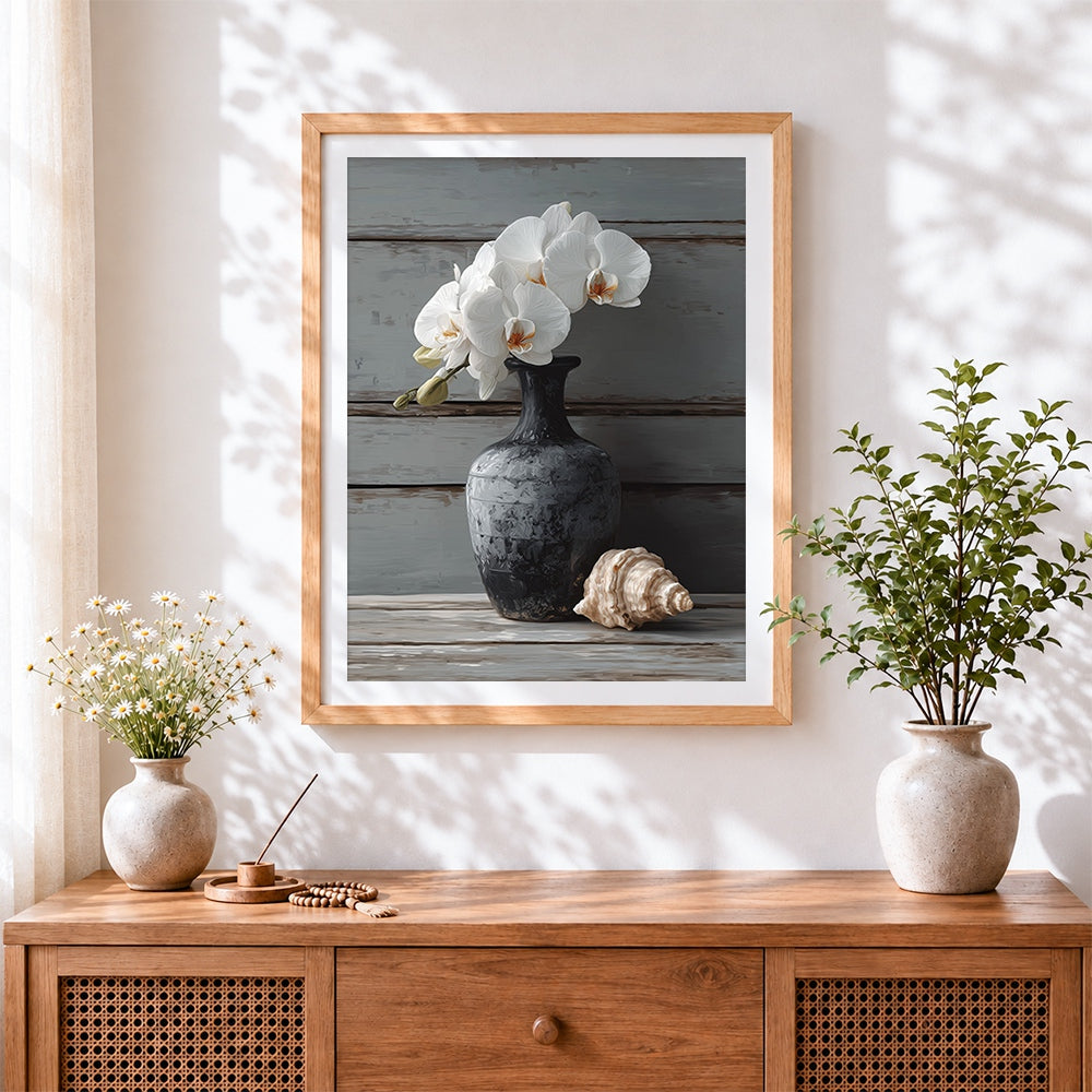 Finished white orchids in a dark vase with shell cross stitch artwork displayed