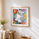 White owl in colourful flowers cross stitch artwork displayed on wall as home decor