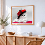White persian kitten in red hat cross stitch artwork displayed on wall as home decor