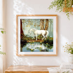 Finished white unicorn by a forest pond cross stitch artwork displayed