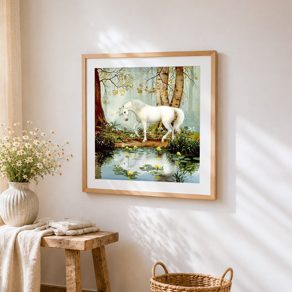 White unicorn by a forest pond cross stitch artwork displayed on wall as home decor