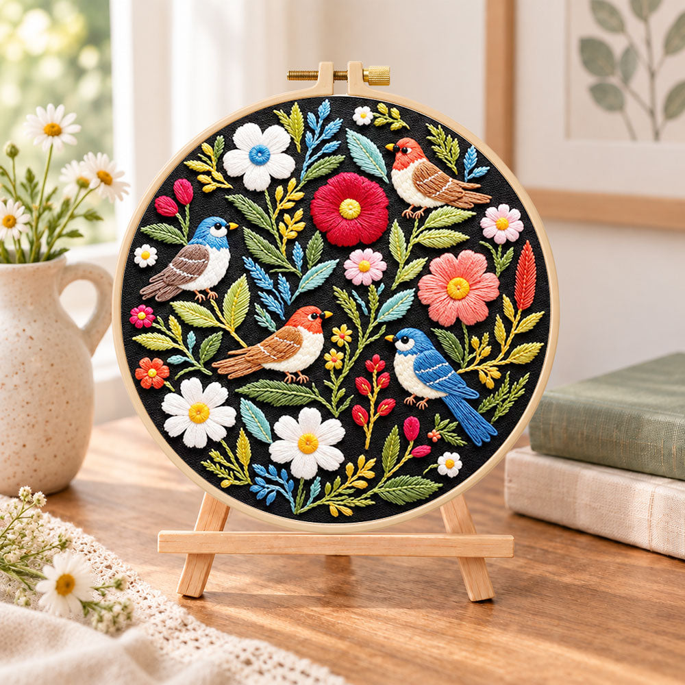 Wild birds and mixed flowers embroidery kit finished hoop displayed on a wooden stand as cosy tabletop decor