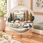 Winter camping valley embroidery kit finished hoop displayed on a wooden stand as cosy tabletop decor