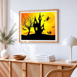 Witch black cat and haunted house at sunset cross stitch artwork displayed on wall as home decor