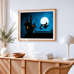 Witch flying over a haunted house cross stitch artwork displayed on wall as home decor