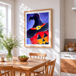 Witch hat on glowing pumpkin cross stitch artwork displayed on wall as home decor