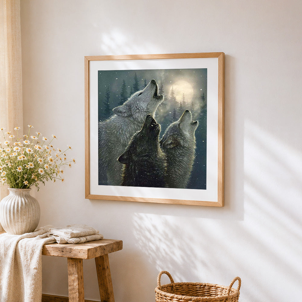 Wolves howling in a snowy forest cross stitch artwork displayed on wall as home decor