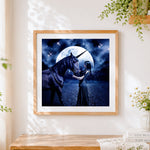 Finished woman and dark unicorn under a full moon cross stitch artwork displayed