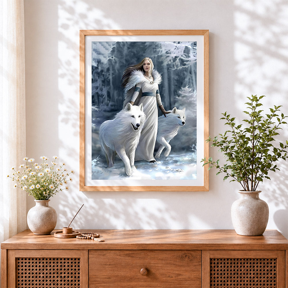 Finished woman and white wolves in a snowy forest cross stitch artwork displayed