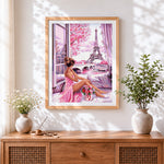 Finished woman by window looking at eiffel tower cross stitch artwork displayed