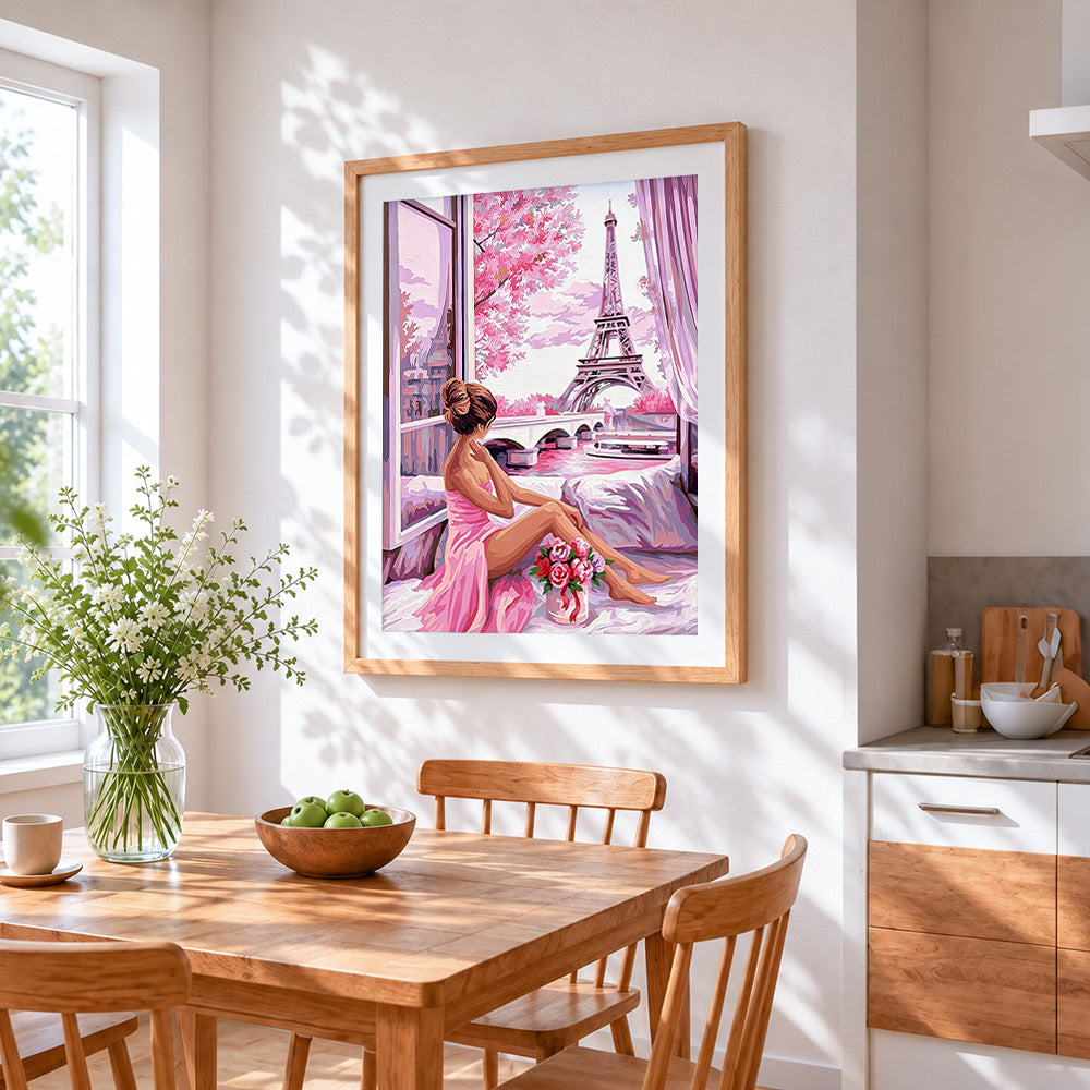 Woman by window looking at eiffel tower cross stitch artwork displayed on wall as home decor