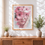 Finished woman holding pink gerbera daisies cross stitch artwork displayed