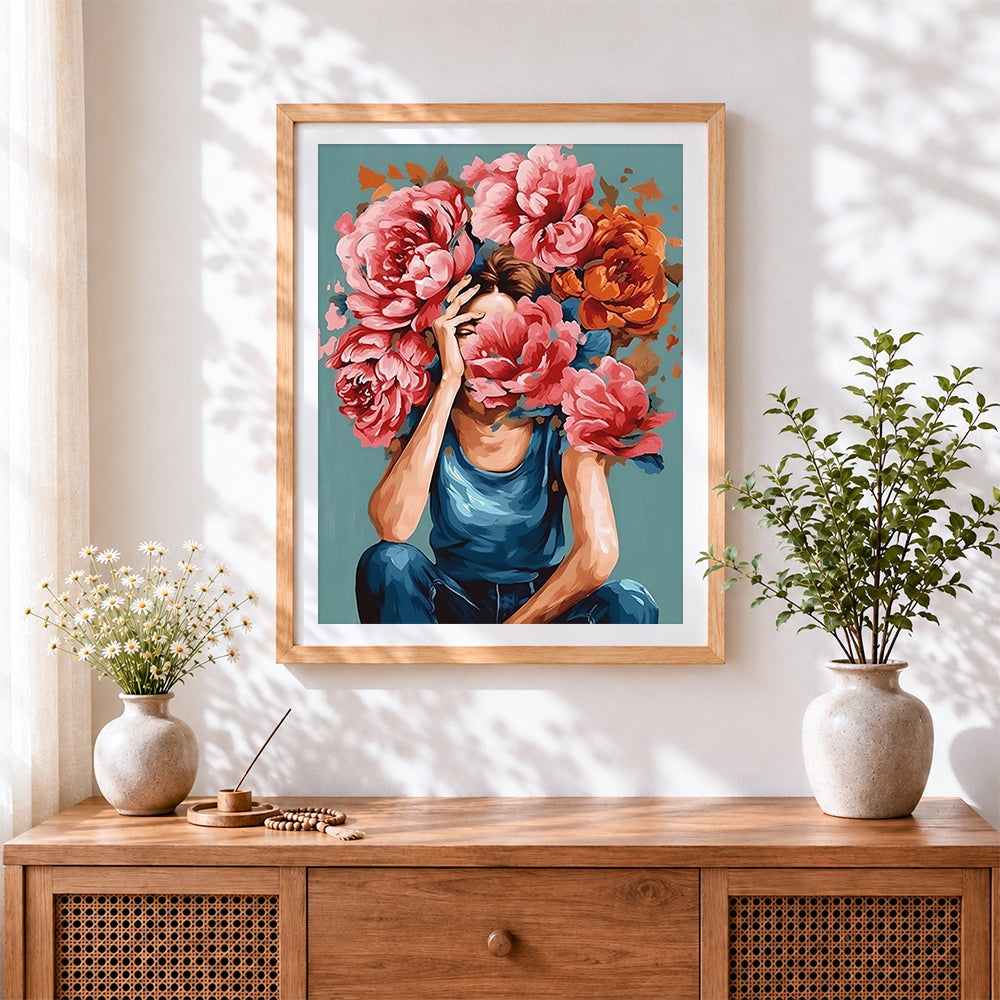 Finished woman holding pink peonies to face cross stitch artwork displayed