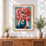 Finished woman holding pink peonies to face cross stitch artwork displayed
