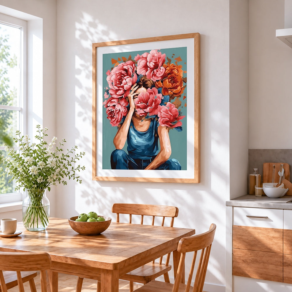 Woman holding pink peonies to face cross stitch artwork displayed on wall as home decor