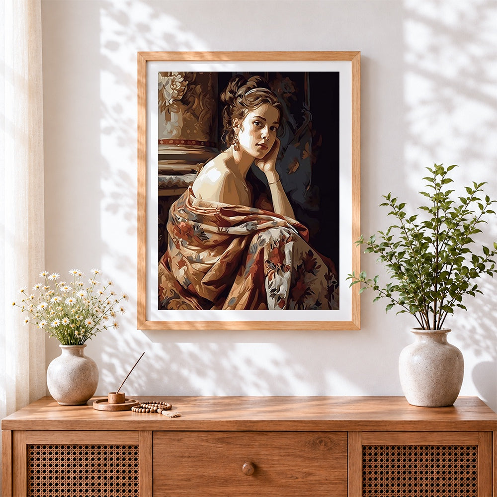 Finished woman in floral wrap cross stitch artwork displayed
