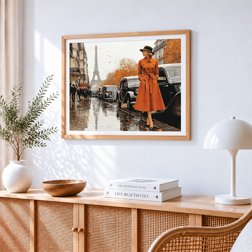 Woman in orange coat in paris cross stitch artwork displayed on wall as home decor