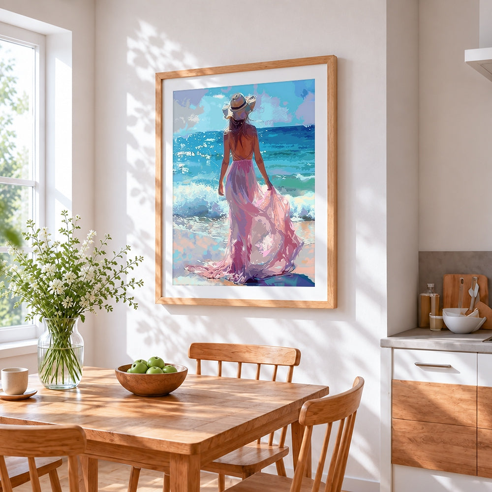 Woman in pink dress at beach cross stitch artwork displayed on wall as home decor