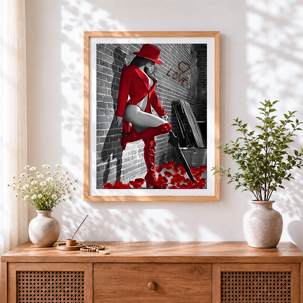 Finished woman in red hat and boots cross stitch artwork displayed
